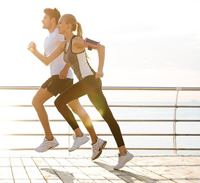 Pareja corriendo activa junto al mar